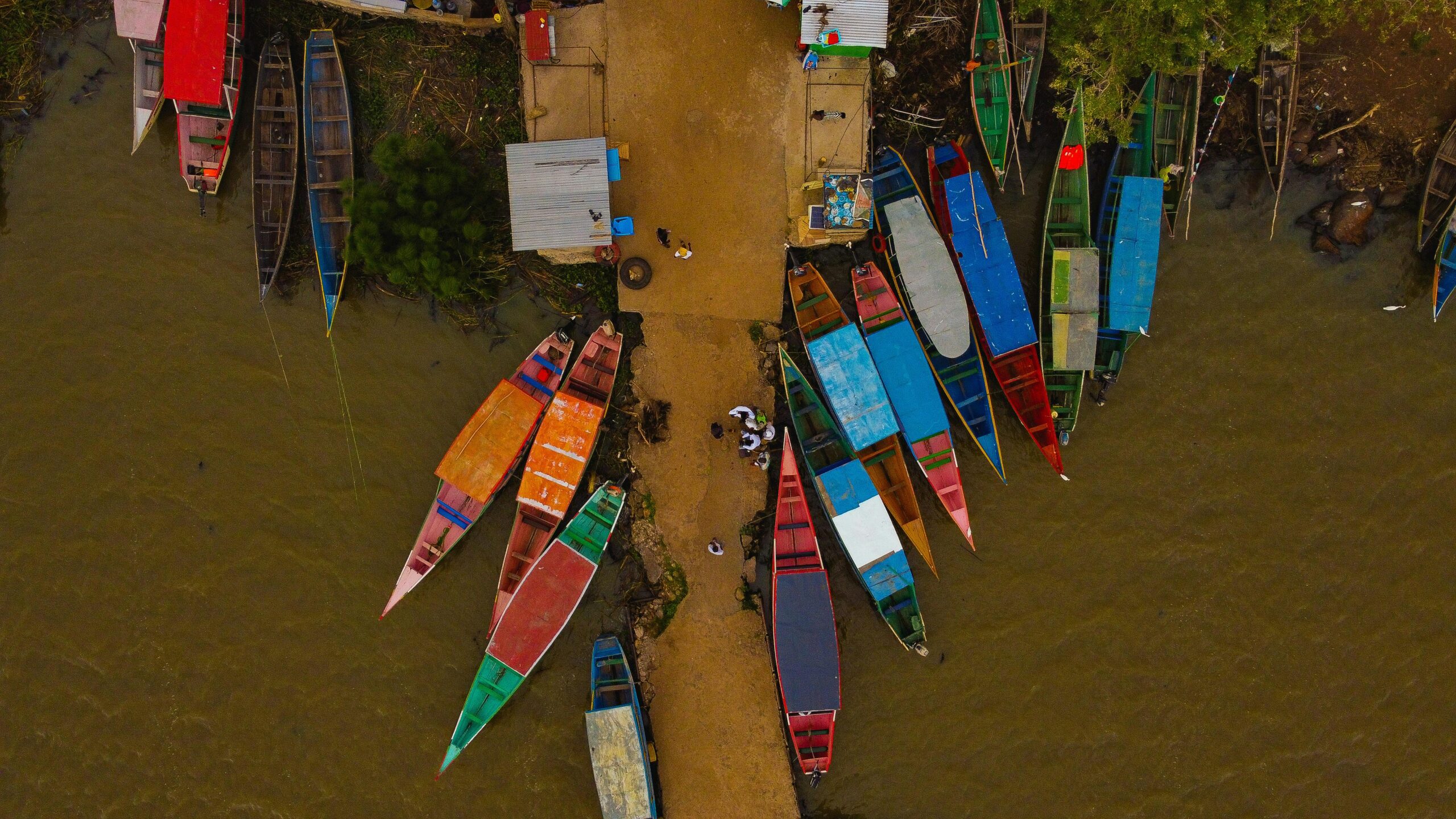 Vibrant boats docked along the shore in Kisumu, Kenya, captured from above.