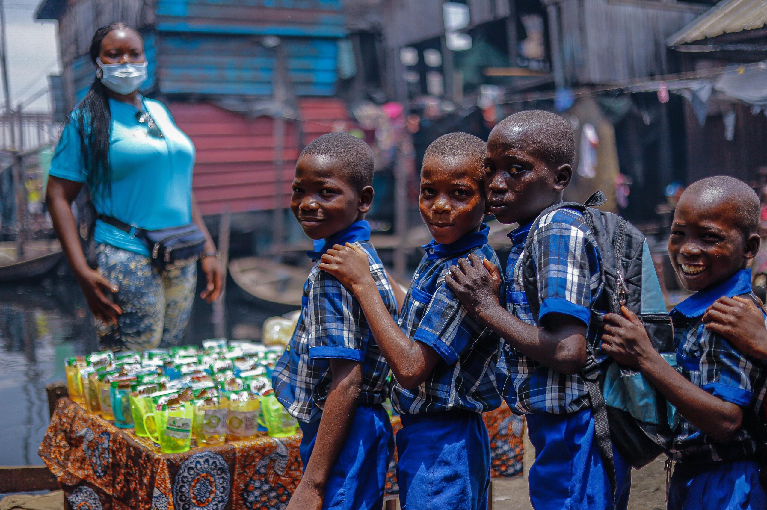 A group of cheerful African school kids in uniforms lined up together outdoors, exuding excitement and happiness.
